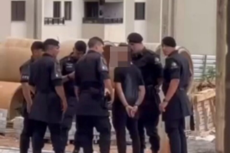 A imagem mostra policiais cercando um suspeito