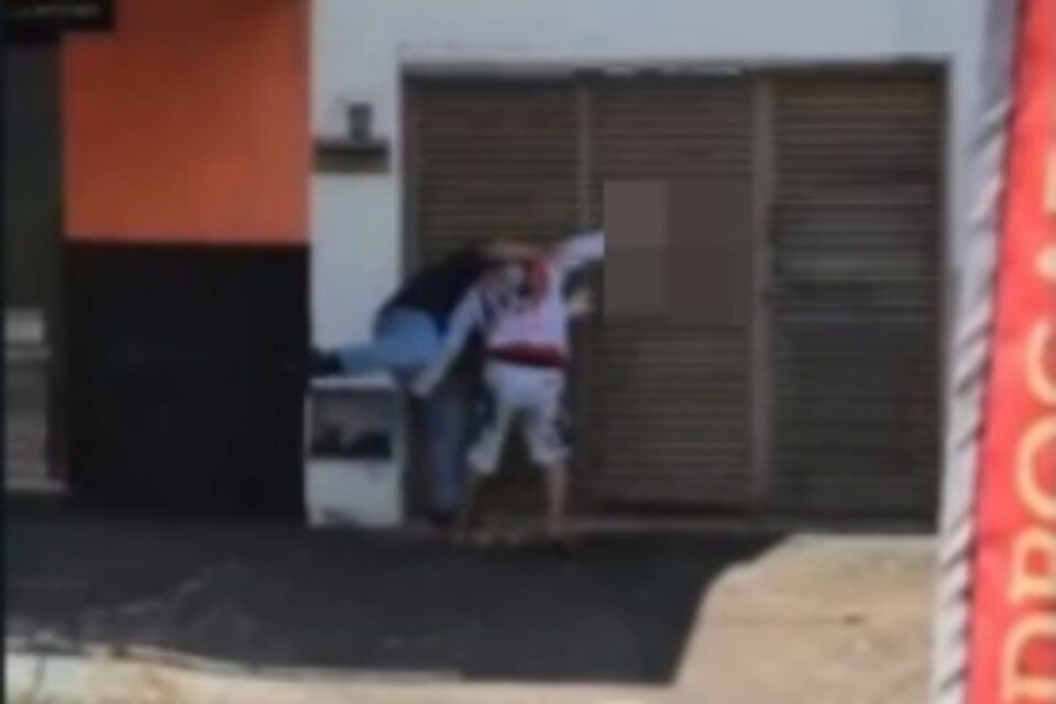 A imagem mostra os jovens brigando em uma calçada