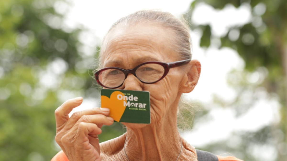 Imagem de uma pessoa idosa segurando o cartão do programa Pra Ter Onde Morar
