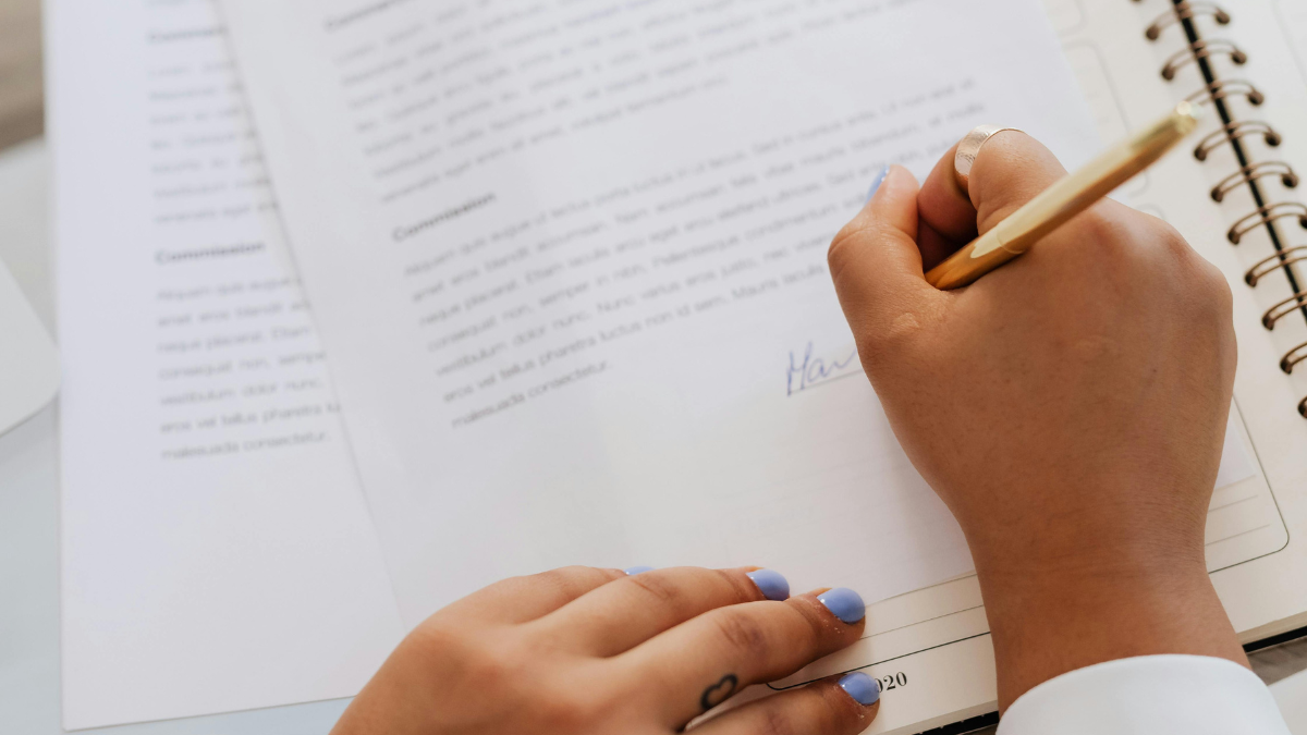 Imagem de uma pessoa escrevendo em um aderno