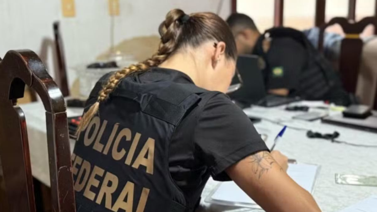 Imagem de uma mulher com o colete da polícia federal de costas