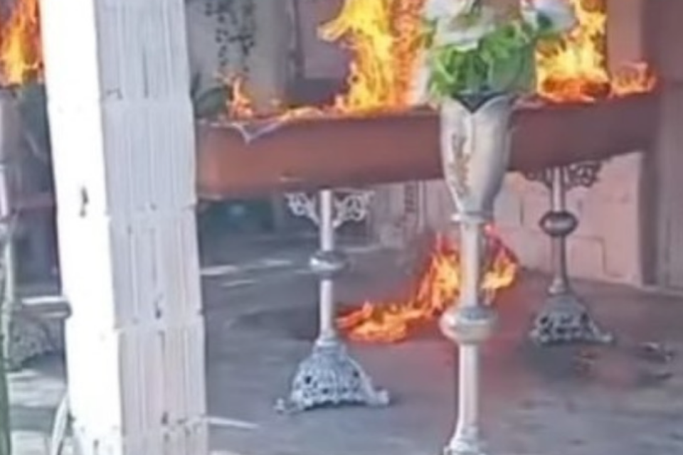 Imagem de um recorte do vídeo com o caixão pegando fogo