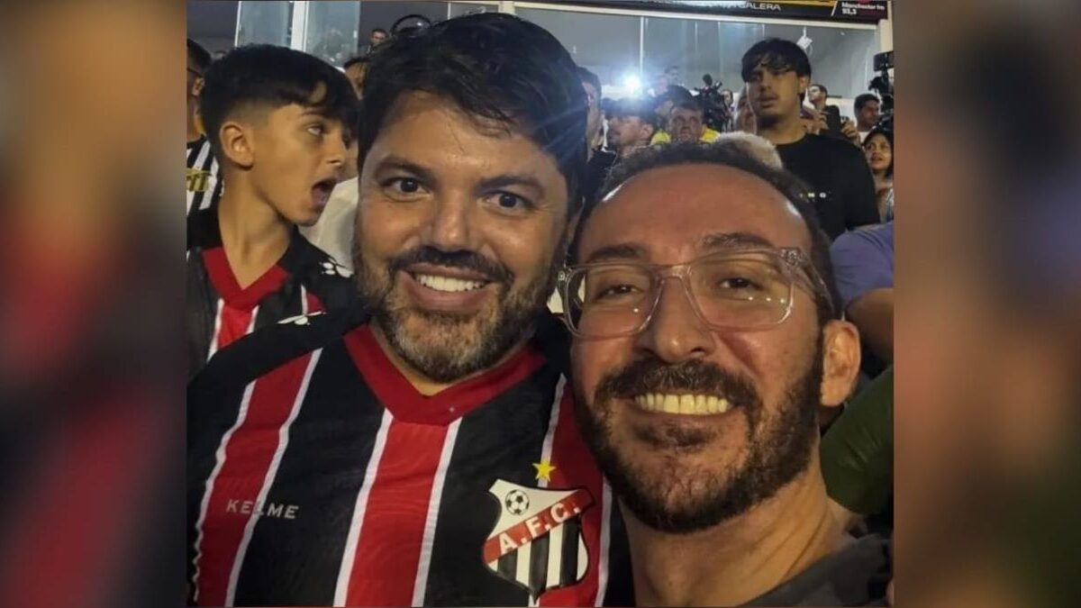 A imagem mostra o prefeito com um jornalista que atuava no esquema