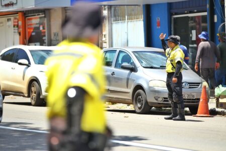 A imagem mostra homens controlando o trânsito