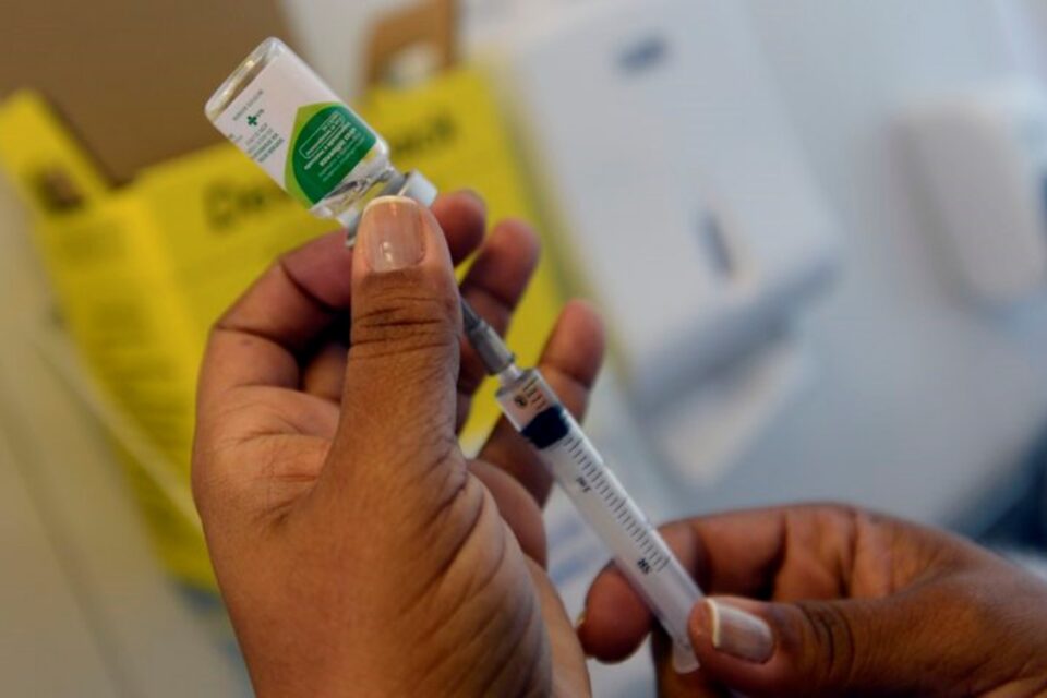 A imagem mostra uma ampola da vacina contra influenza