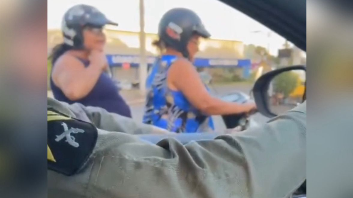 Mulher coloca capacete após alerta de PM (Foto: Reprodução)