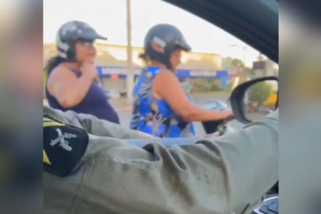 Mulher coloca capacete após alerta de PM (Foto: Reprodução)