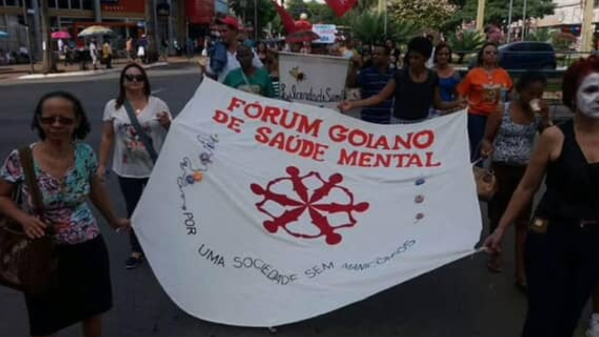 Imagem de pessoas segurando um cartaz do forúm goiano de saúde mental