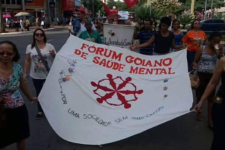 Imagem de pessoas segurando um cartaz do forúm goiano de saúde mental