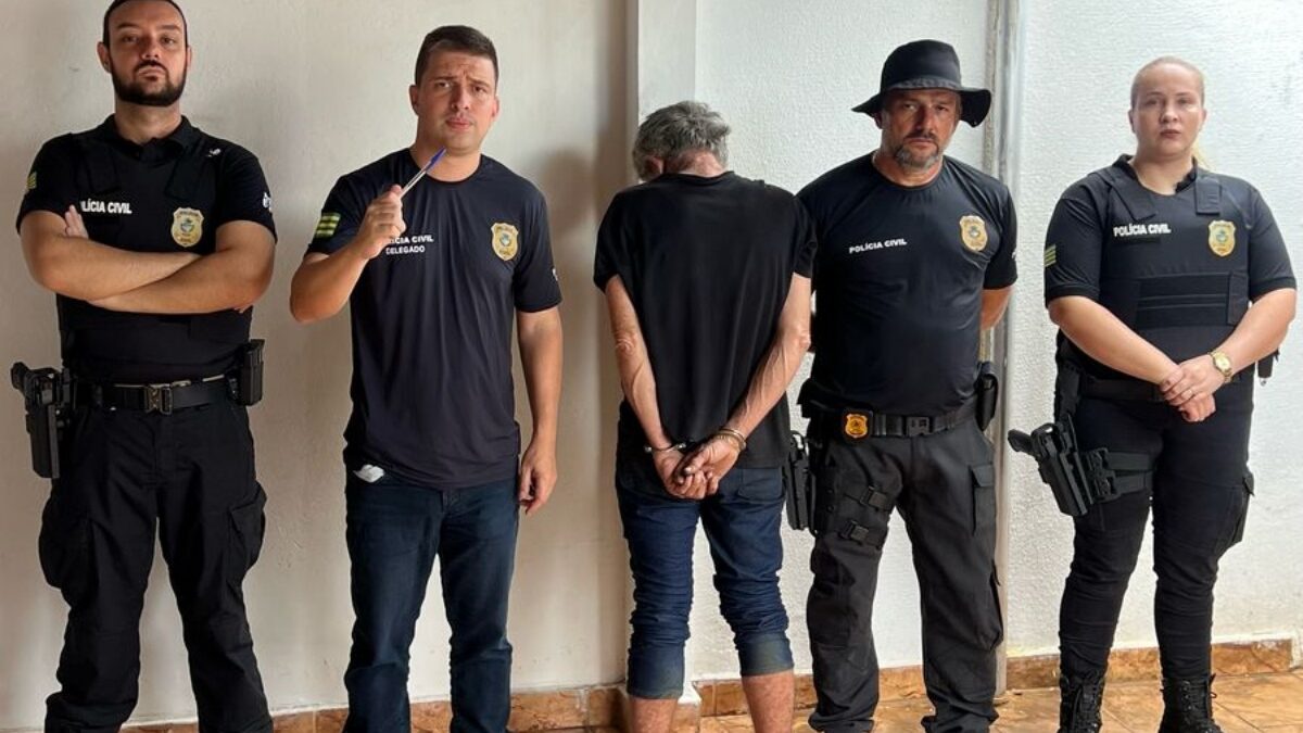 Imagem do homem preso ao lado do delegado e policiais