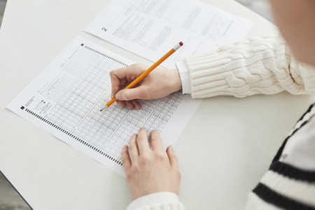 Imagem de uma pessoa preenchendo o gabarito de uma prova