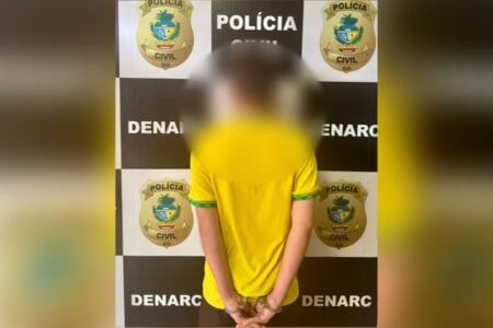 Imagem do homem preso de costas, com a foto borrada