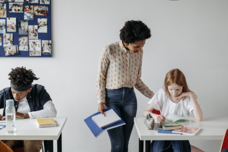 Imagem de uma mulher dando aula para alunos jovens