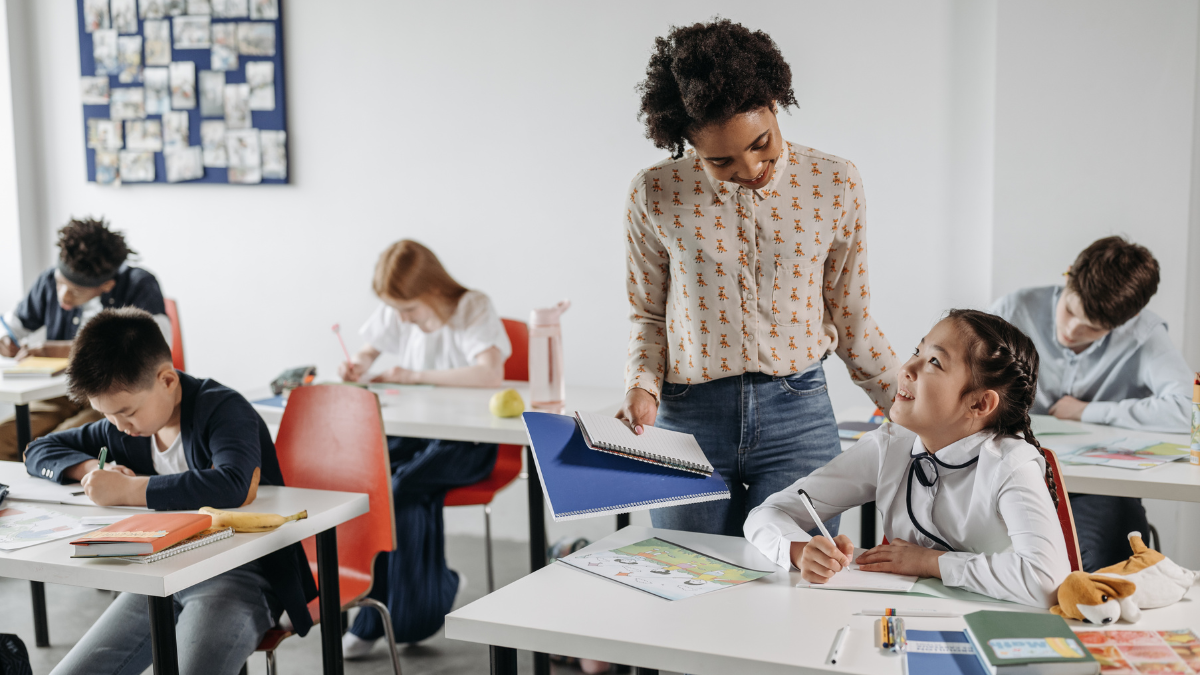 Imagem de uma professora orientando os alunos