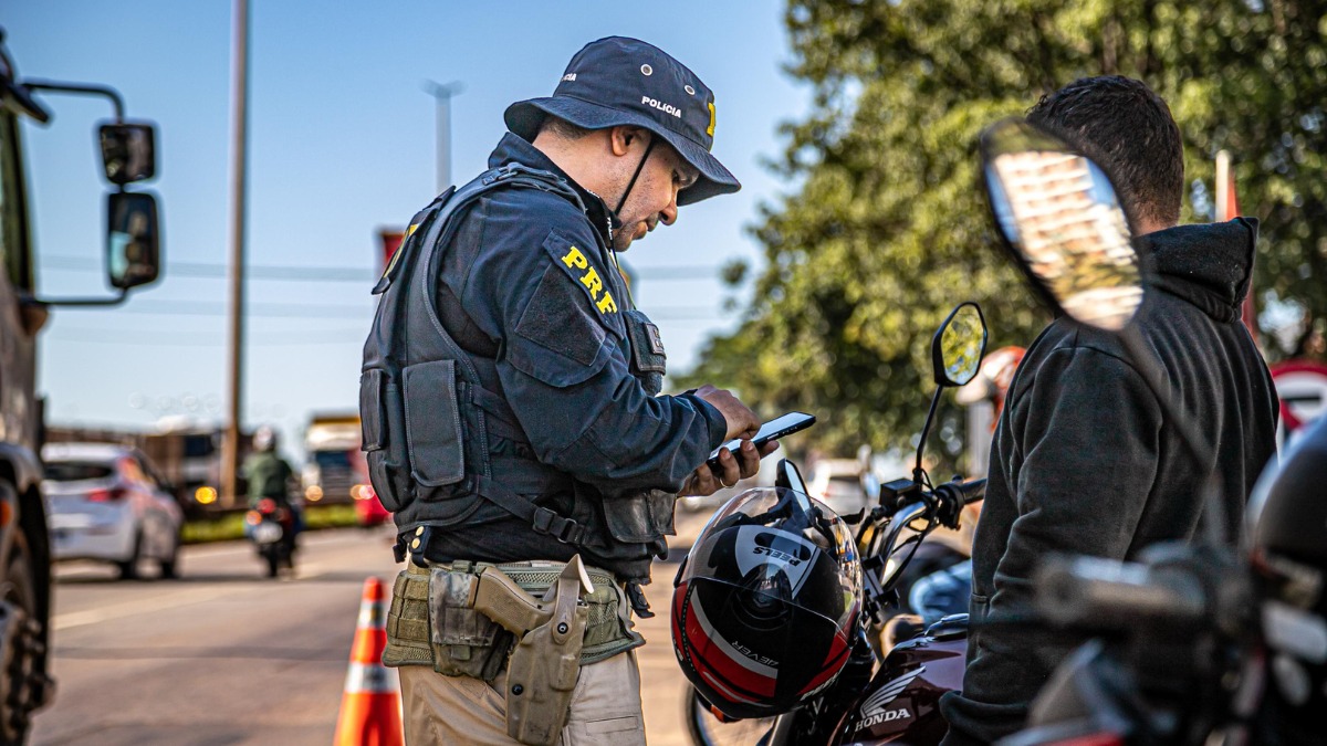A imagem mostra agentes aplicando multa