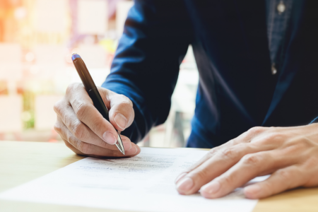 Imagem de um homem escrevendo em uma prova