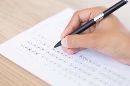 Imagem de uma pessoa preenchendo o gabarito de uma prova