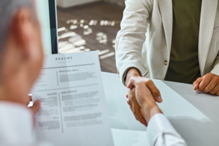Imagem de dois homens apertando as mãos durante uma entrevista de emprego