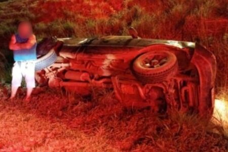 Imagem do idoso ao lado do veículo capotado