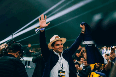 Homem feliz com braços para cima e chapeu.