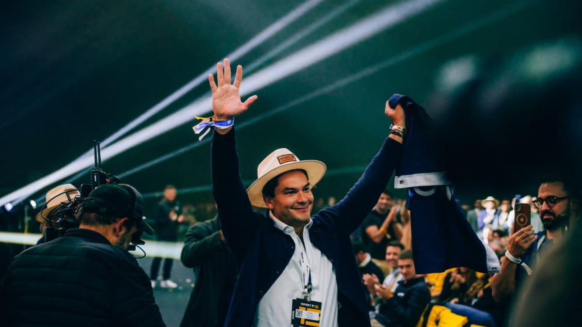 Homem feliz com braços para cima e chapeu.