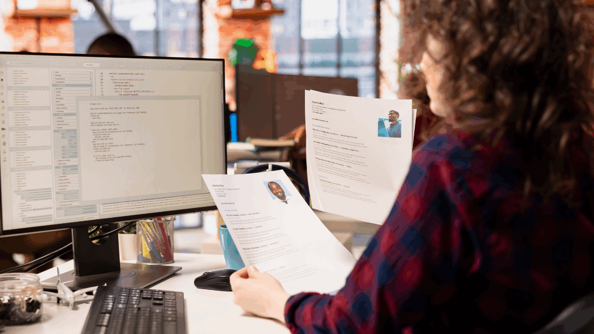 Imagem de uma pessoa analisando currículos