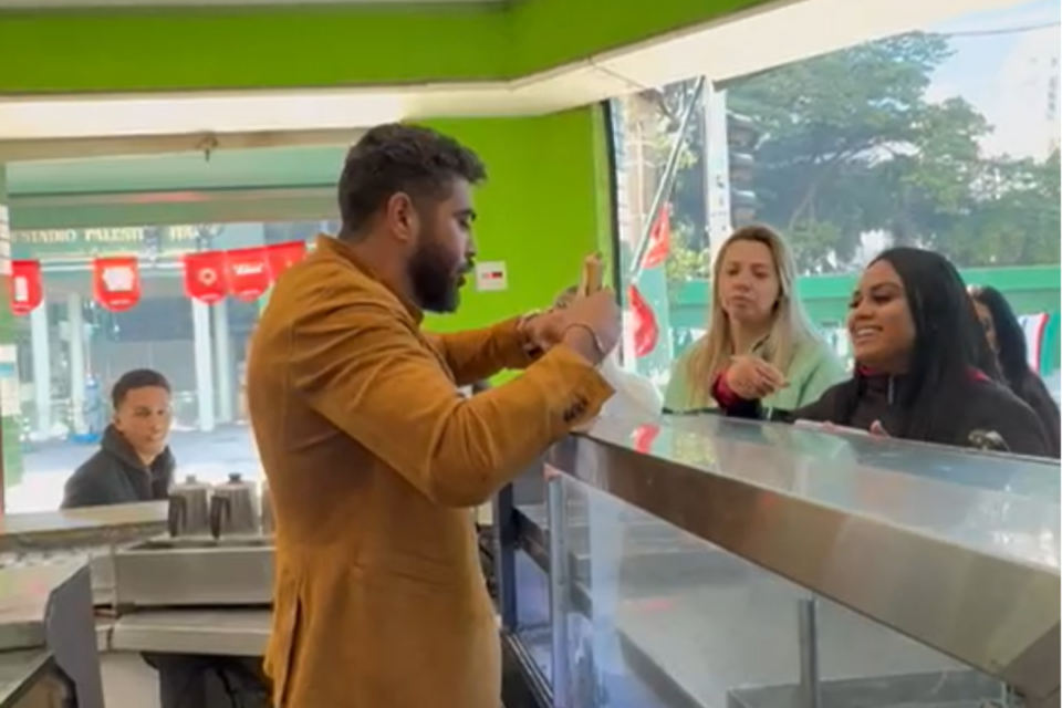 Henrique, da dupla com Juliano, serve salgados em padaria após show