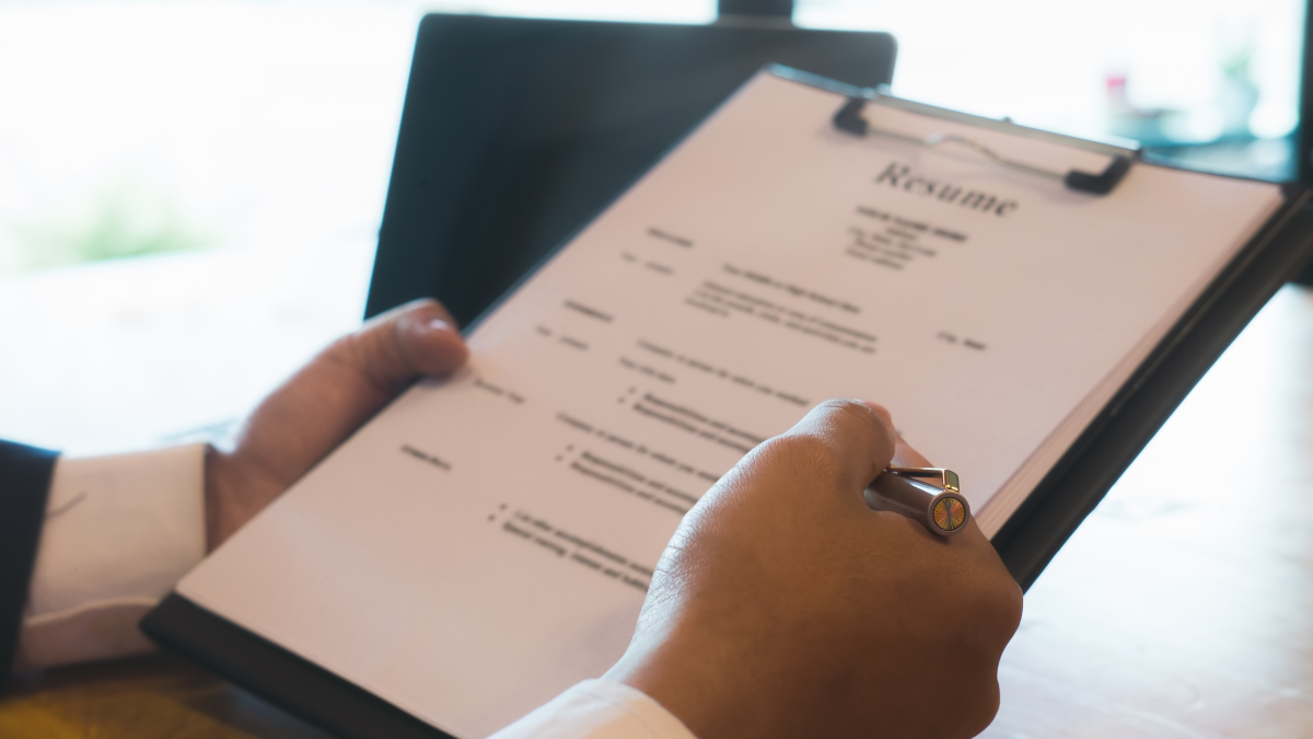 Imagem de uma pessoa analisando o currículo de um candidato