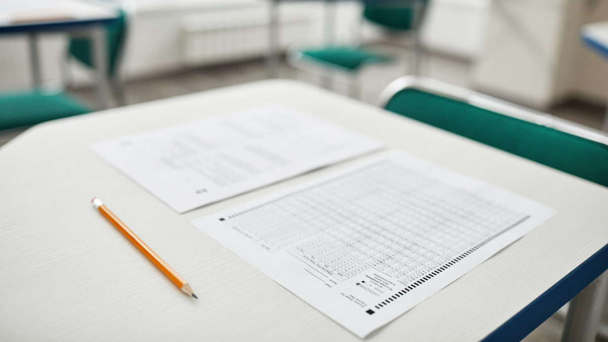 Imagem de um gabarito em cima de uma carteira escolar