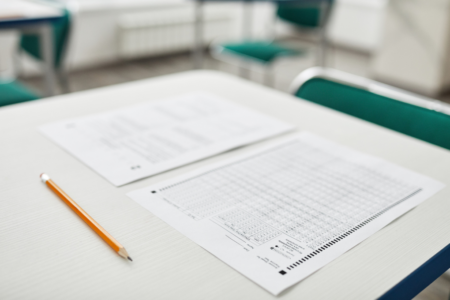 Imagem de um gabarito em cima de uma carteira escolar