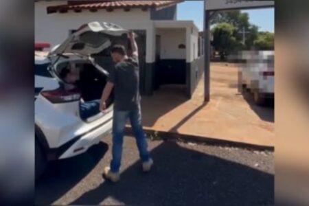 Imagem do homem sendo levado para delegacia
