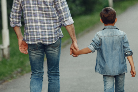 Imagem de um pai segurando a mão de uma criança