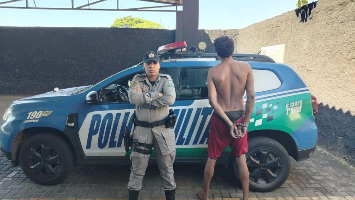 Imagem do suspeito preso em frente a uma viatura