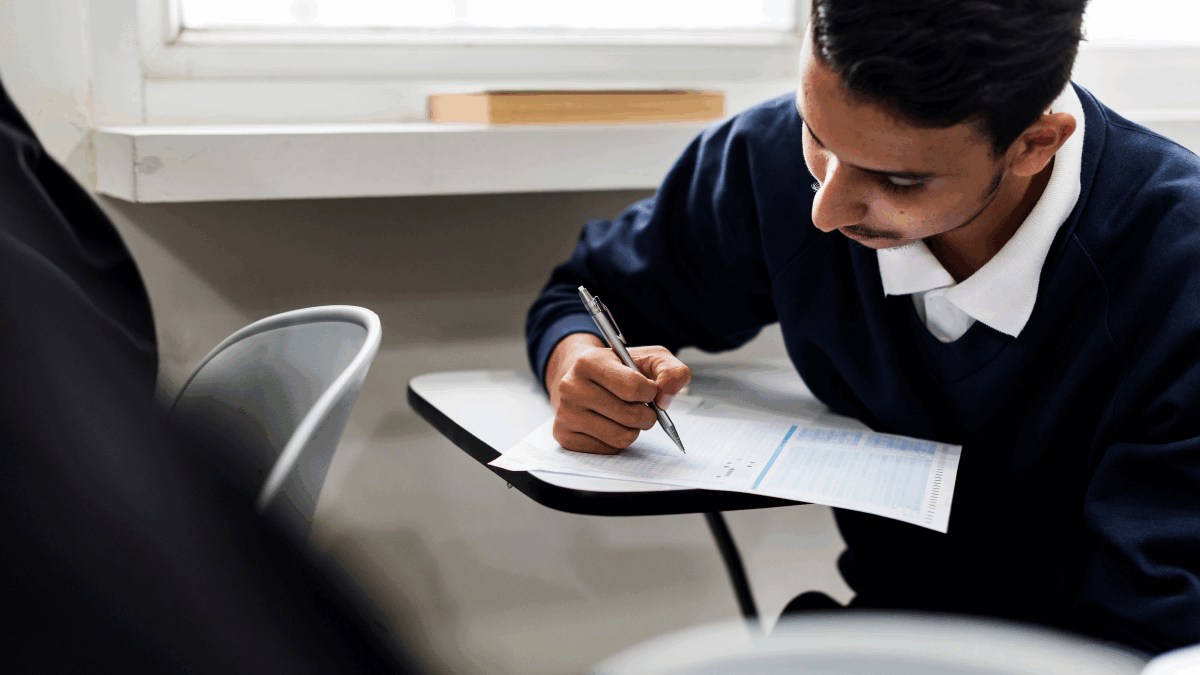 Imagem de um homem escrevendo em uma prova