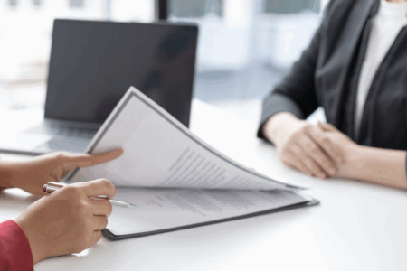 Imagem de uma pessoa analisando alguns currículos