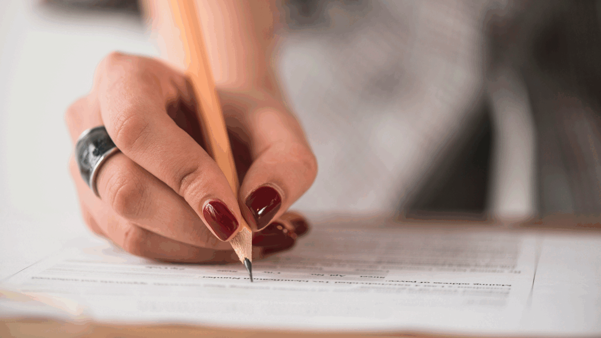 Imagem de uma pessoa escrevendo em uma folha