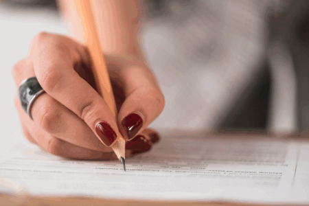 Imagem de uma pessoa escrevendo em uma folha