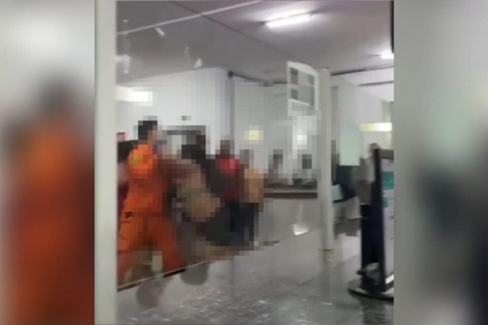 Momento em que o bombeiro tenta segurar a mulher