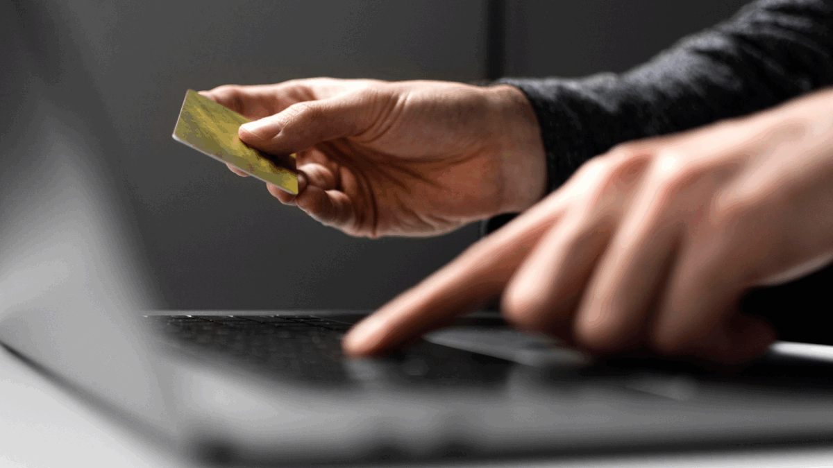 Homem com cartão de crédito no computador