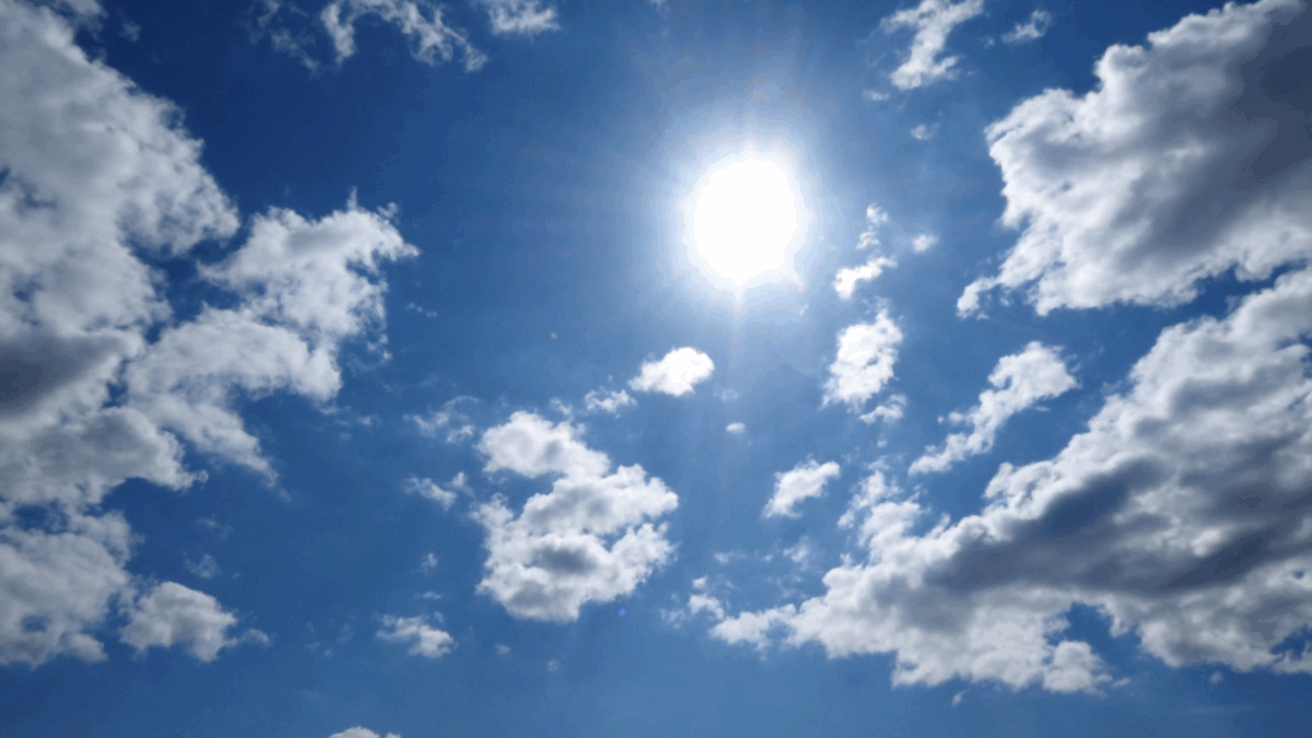 Imagem de um céu com nuvens e um sol radiante