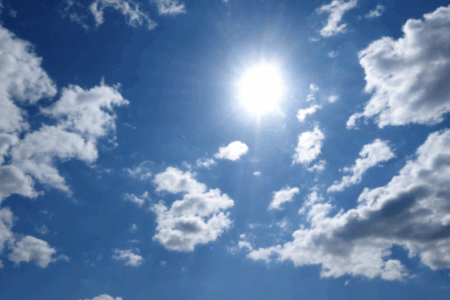 Imagem de um céu com nuvens e um sol radiante