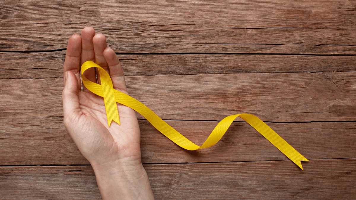 Imagem de uma pessoa segurando a fitinha amarela do setembro amarelo