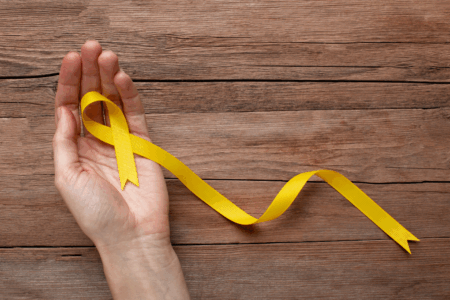 Imagem de uma pessoa segurando a fitinha amarela do setembro amarelo