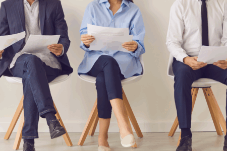 Imagem de pessoas segurando currículos, esperando serem chamadas para a entrevista de emprego