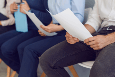 Imagem de pessoas sentadas esperando pela entrevista de emprego