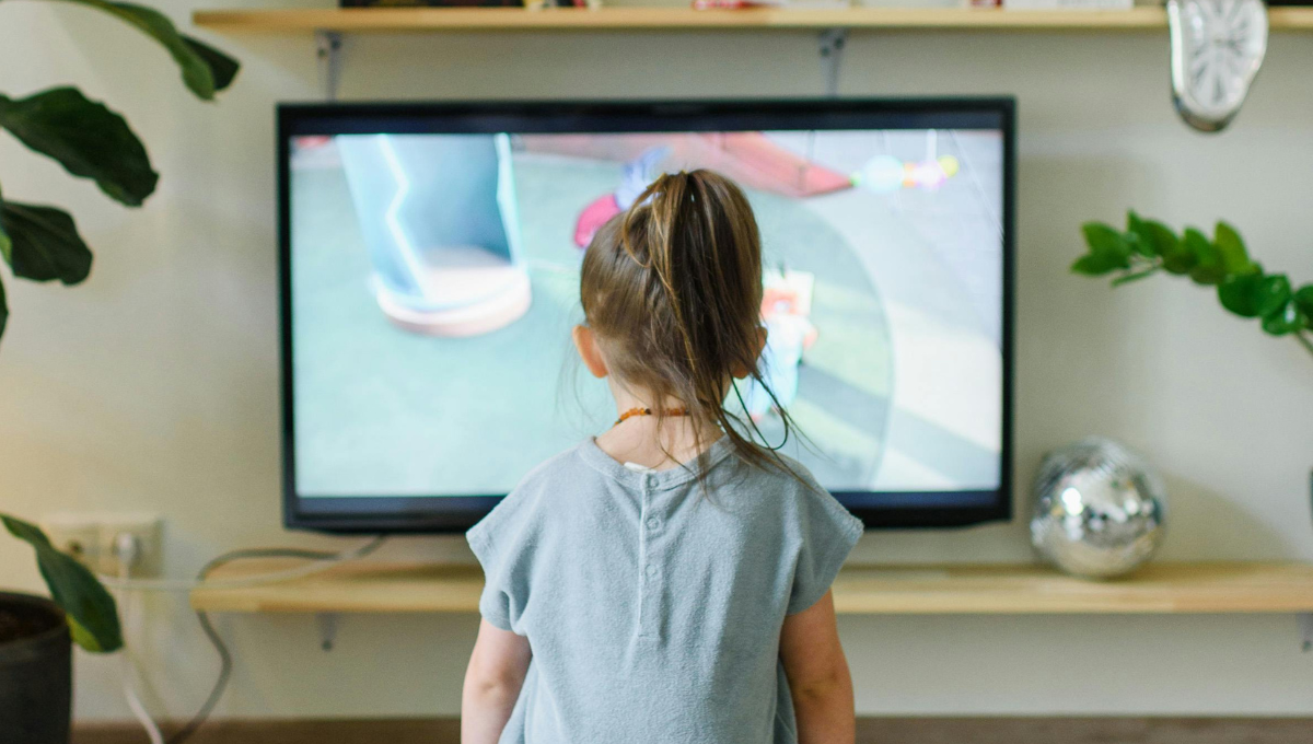 Imagem de uma criança assistindo televisão