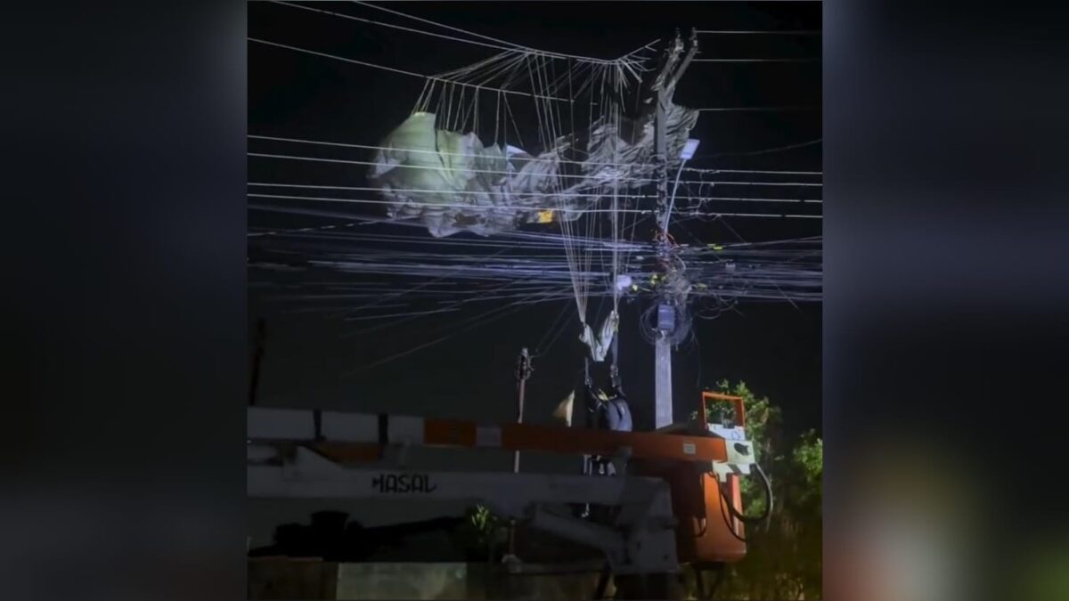 Moradores registram paraquedista pendurado em fios de alta tensão (Foto: reprodução)