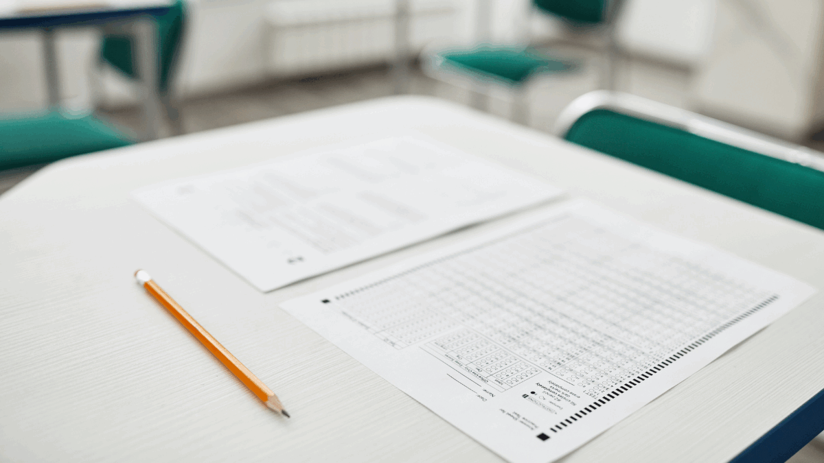 Imagem de uma prova e um lápis em uma carteira