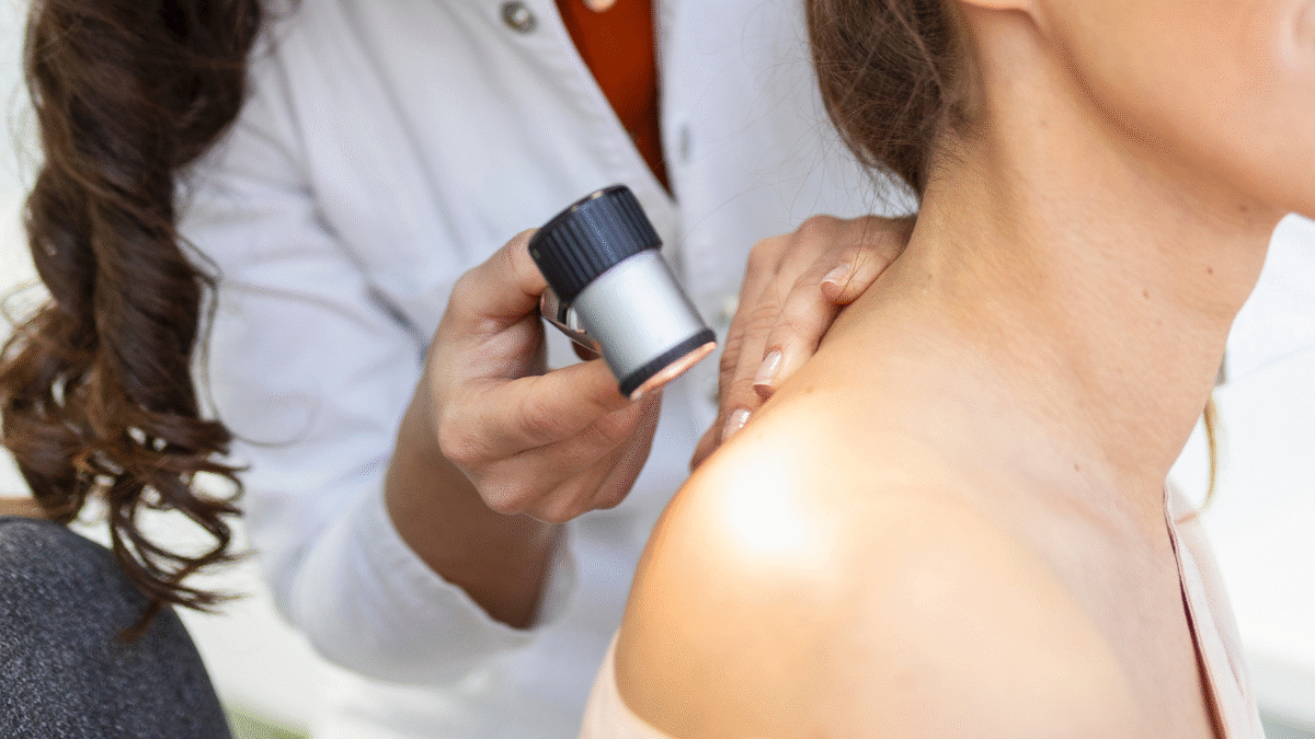 Imagem de uma dermatologista analisando a pele de um paciente