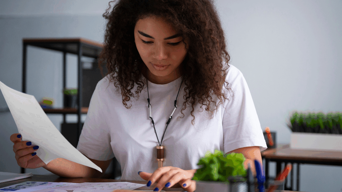 Imagem de uma mulher analisando os currículos de candidatos